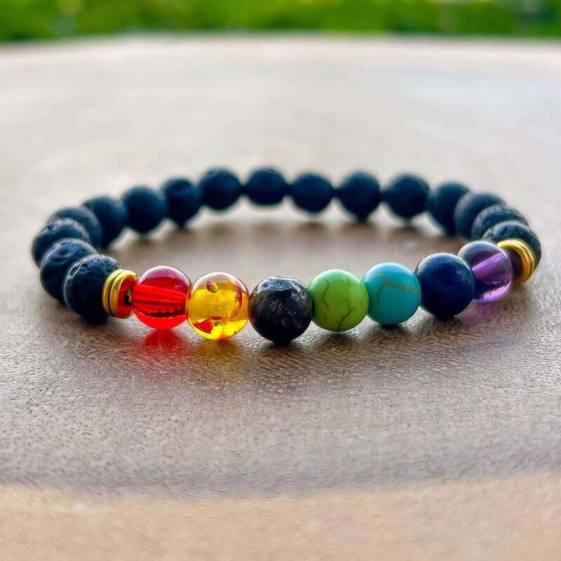 Essential oil diffusing bracelet! Crafted from highly absorbent lava stone, this 7 Chakra Lava Stone Bracelet allows you to enjoy the soothing benefits of aromatherapy at all times. Unisex bracelet, magiccrystals. 7 Chakra and Black Lava Stone - Lava Stone Bracelet