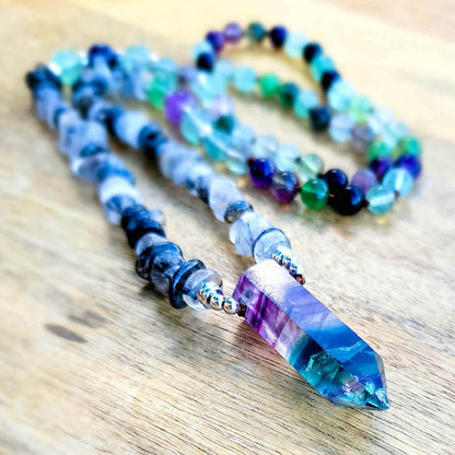 Looking for Fluorite Crystal Mala - Handcrafted for Chakra Energy? Shop at Magic Crystals. Wearing, carrying, or meditating with this Flurotie crystal mala can open the mind and heart to higher guidance. Features a combination of Tourmalinated Quartz and Fluorite beads with a double point as a center piece. SHIPS FREE