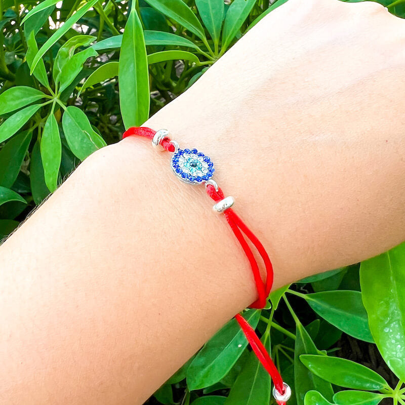 Greek-Evil-Eye-Red-String-Bracelet. Shop at Magic Crystals for Protection. The Red String Bracelet has been worn throughout history in many cultures as a symbol of protection, faith, and good luck and acts as a shield from negativity and actually has many positive effects. In quite a few cultures a red string bracelet is believed to have magical powers.