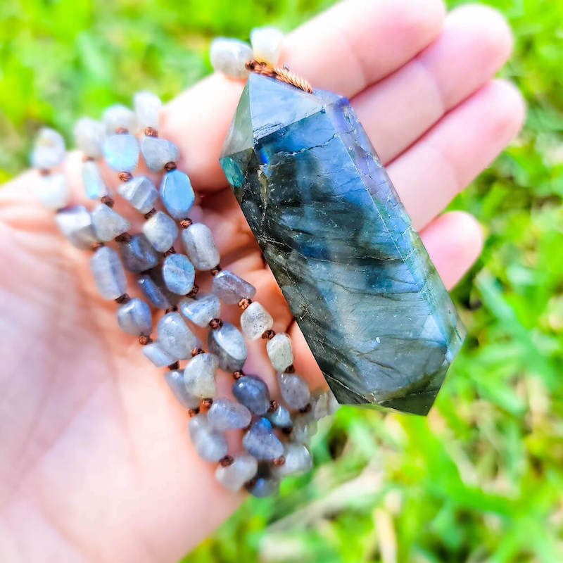 Cleanse your Third Eye Chakra with the warm vibrations of this Labradorite crystal mala! Features a combination of labradorite double point and labradorite chips. Handmade exclusively by Magic Crystals. The main focal point of the mala is the energizing Labradorite gemstone pendant. Hand-knotted Larvikite Prayer Beads.