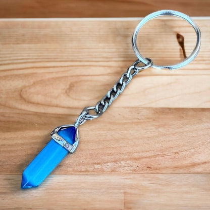 Cat's Eye keychain. Shop at Magic Crystals for Crystal Keychain, Pet Collar Charm, Bag Accessory, natural stone, crystal on the go, keychain charm, gift for her and him. Cat's Eye Natural Stone Keychain, Crystal Keychain, Cat's Eye Crystal Key Holder. pink, yellow, white, blue, and green gemstone.