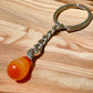 Tumbled Stone Carnelian Keychain. Carnelian keychain. Shop at Magic Crystals for Crystal Keychain, Pet Collar Charm, Bag Accessory, natural stone, crystal on the go, keychain charm, gift for her and him. Carnelian is a great for courage. Carnelian Natural Stone Keychain, Crystal Keychain, Carnelian Crystal Key Holder. Yellow gemstone.