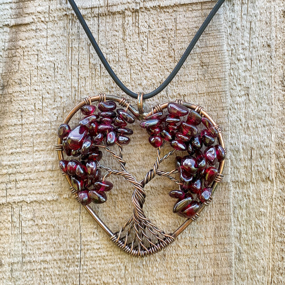 Garnet -Tree-of-Life-Copper-Wire-Heart-Necklace. Looking for Copper Jewelry? Magic Crystals offers handmade Heart Copper Wire Wrapped,  Tree Of Life,  Hematite Pendant Necklace, 7th Anniversary Gift, Yggdrasil Necklace for Him or Her Gift. Heart Gift perfect for any occasion. Heart Necklace With gemstones. Tree of Life made of copper in a pendant necklace.