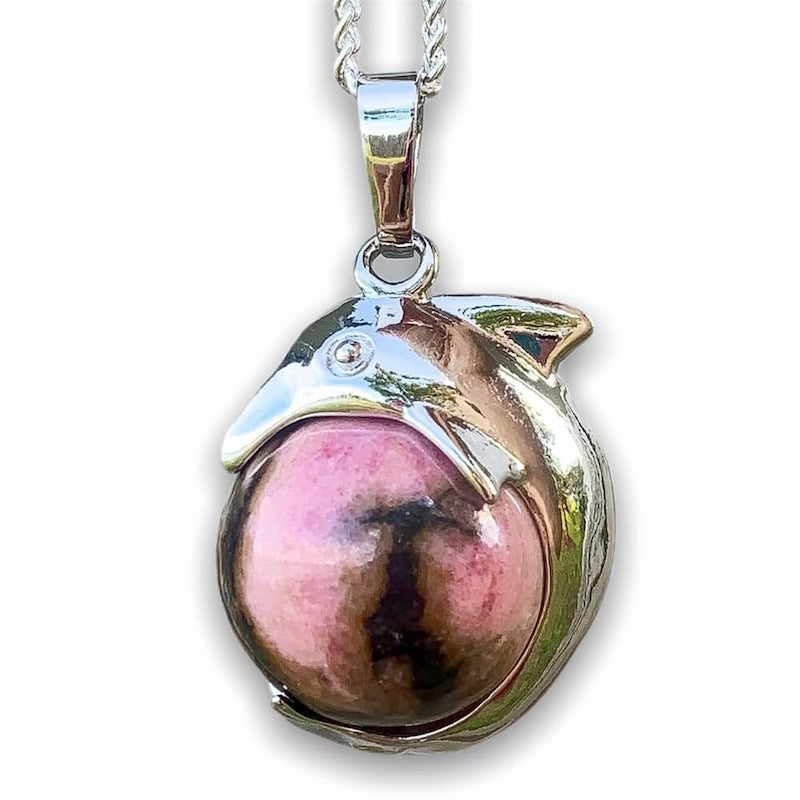   Rhodonite-Sphere-Dolphin-Pendant-Necklace. Dolphin Necklace - Elegant Ocean-Themed Jewelry for Women Dolphin Charm Necklace at Magic Crystals. Boho Style Jewelry with Natural Gemstones. Stone Carved Dolphin Necklace Pendant, Beach Surf Ocean Boho Gemstone Whale Fairtrade Gift. These beautiful stone necklaces are all hand carved.