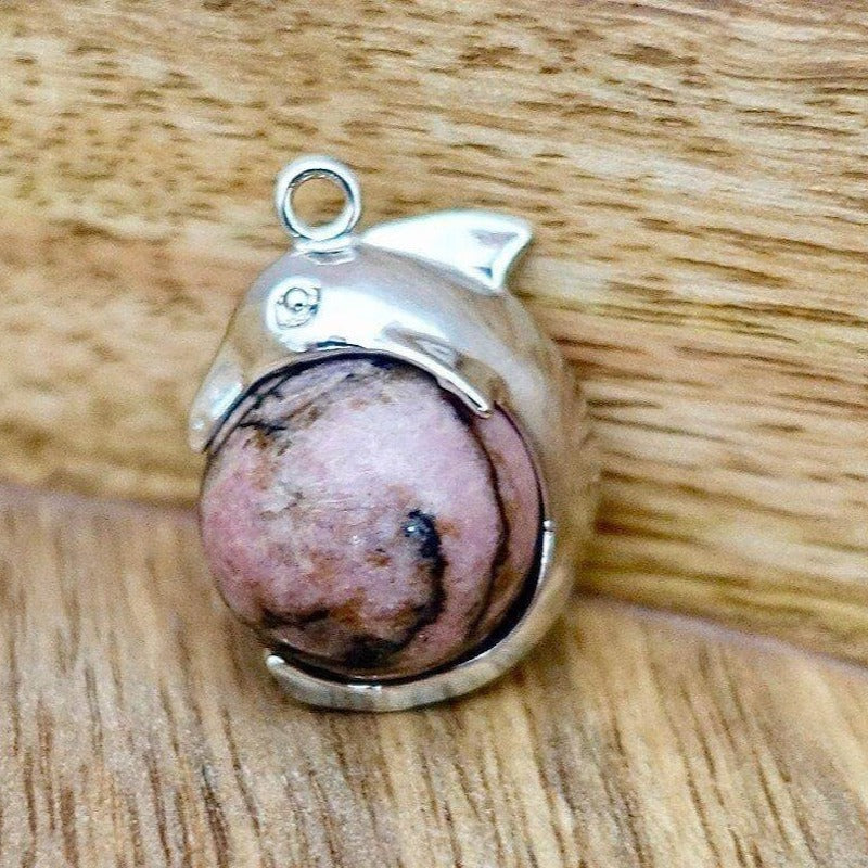    Rhodonite-Sphere-Dolphin-Pendant-Necklace. Dolphin Necklace - Elegant Ocean-Themed Jewelry for Women Dolphin Charm Necklace at Magic Crystals. Boho Style Jewelry with Natural Gemstones. Stone Carved Dolphin Necklace Pendant, Beach Surf Ocean Boho Gemstone Whale Fairtrade Gift. These beautiful stone necklaces are all hand carved.