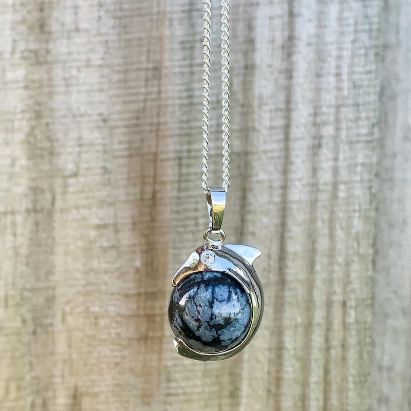    Snowflake-Obsidian-Sphere-Dolphin-Pendant-Necklace. Dolphin Necklace - Elegant Ocean-Themed Jewelry for Women Dolphin Charm Necklace at Magic Crystals. Boho Style Jewelry with Natural Gemstones. Stone Carved Dolphin Necklace Pendant, Beach Surf Ocean Boho Gemstone Whale Fairtrade Gift. These beautiful stone necklaces are all hand carved.